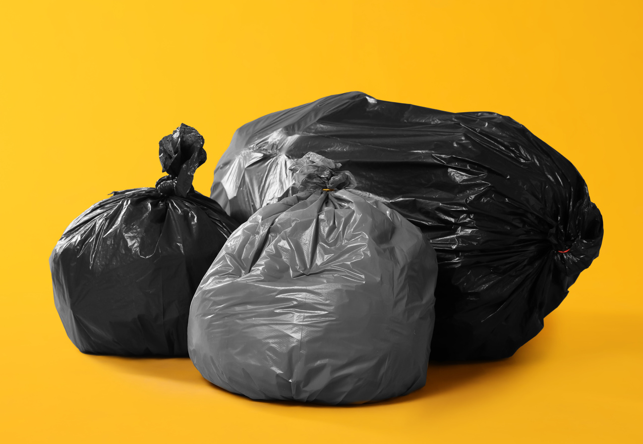 Trash Bags Full of Garbage on Yellow Background